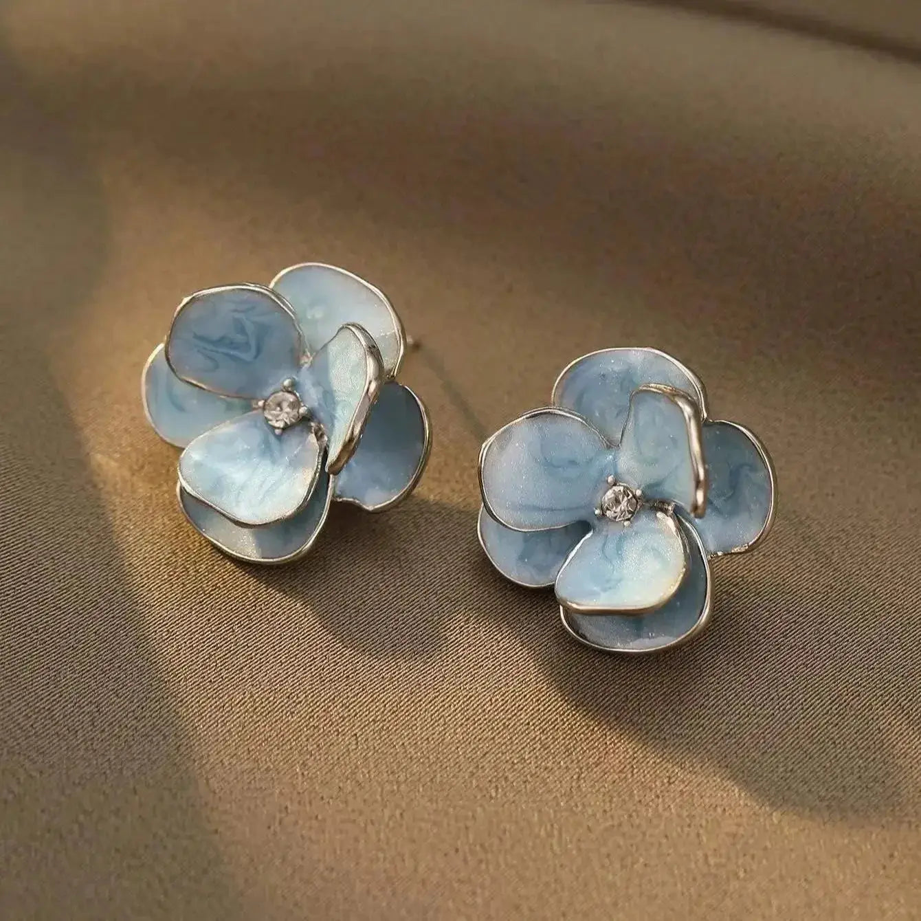 Pair of blue enamel flower earrings with silver-tone edges and crystal centers for women