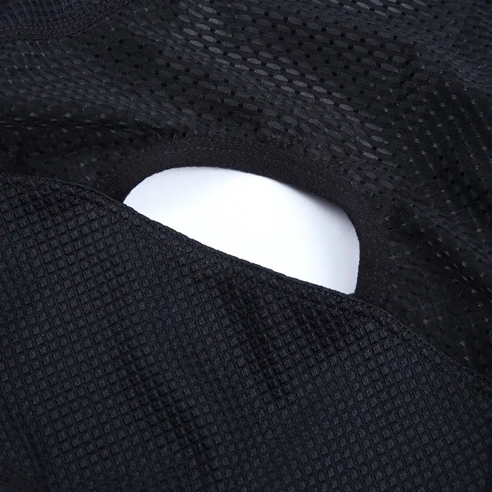 Cycling jersey fabric close-up in black mesh with a white curved insert visible