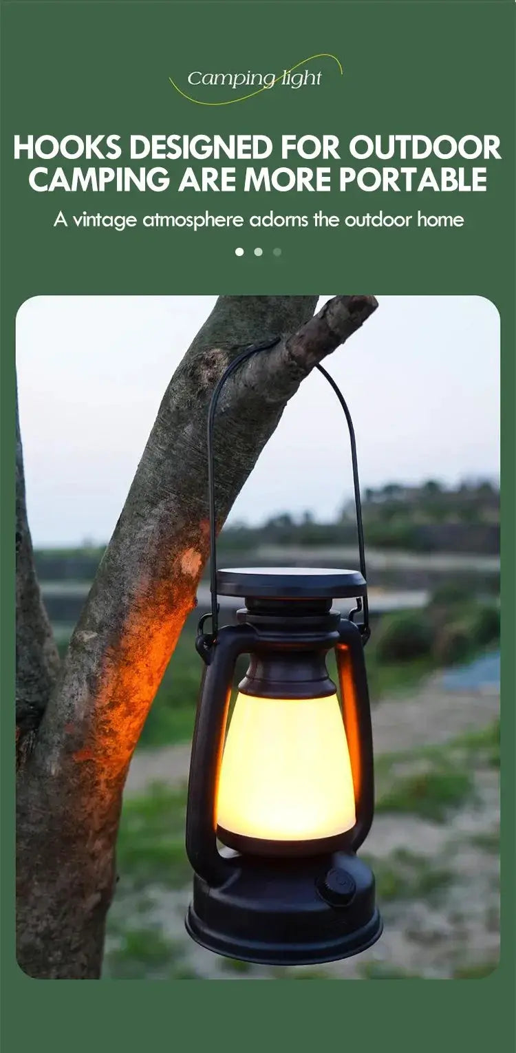 Camping lantern with black metal frame and warm LED glow hanging from a tree