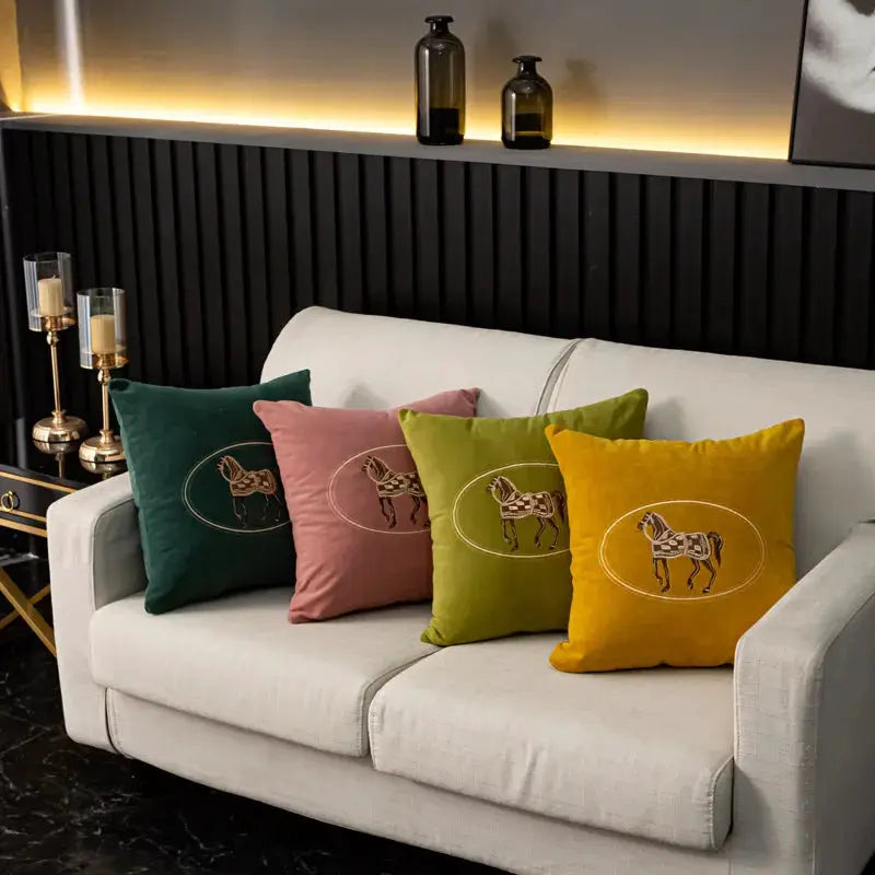 Cushion covers set of 4 with hand-embroidered horse design on a white sofa in green, pink, olive and mustard.