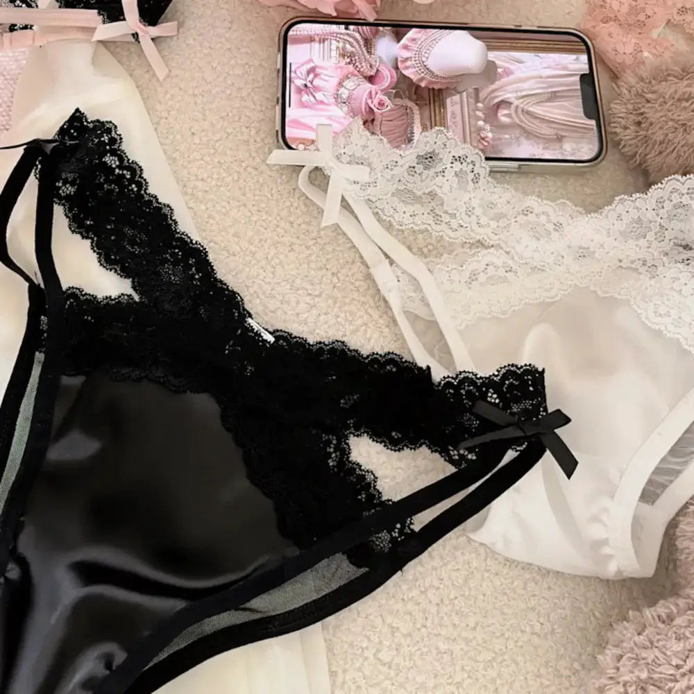 Two-piece lace lingerie set in black and white with satin panels and bow accents.