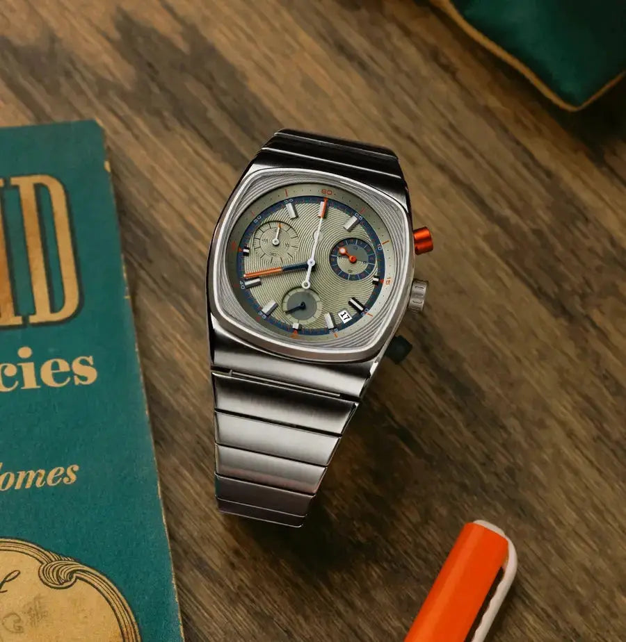 CILOA vintage men's automatic watch with stainless steel bracelet, beige dial, blue accents, and orange crown.