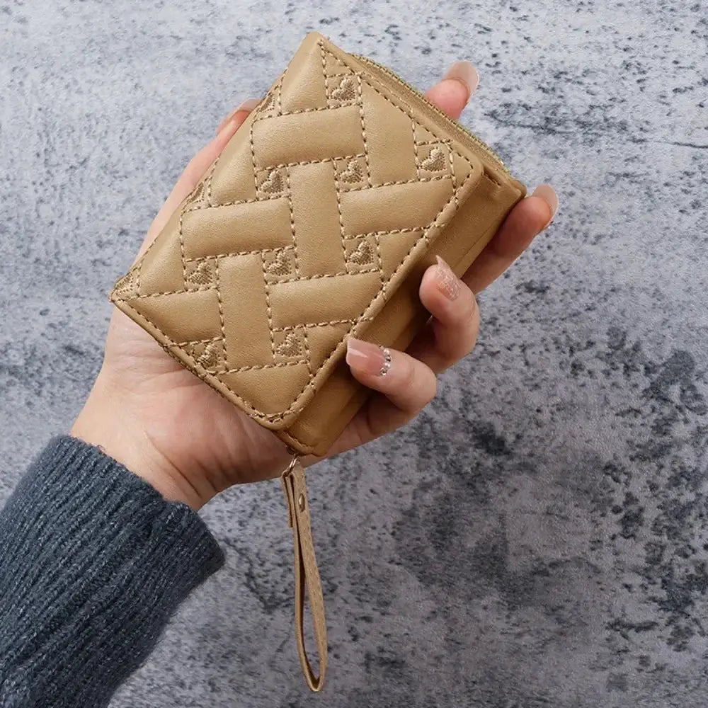 Women's tan quilted wallet by Simples Market with top zipper and wrist strap