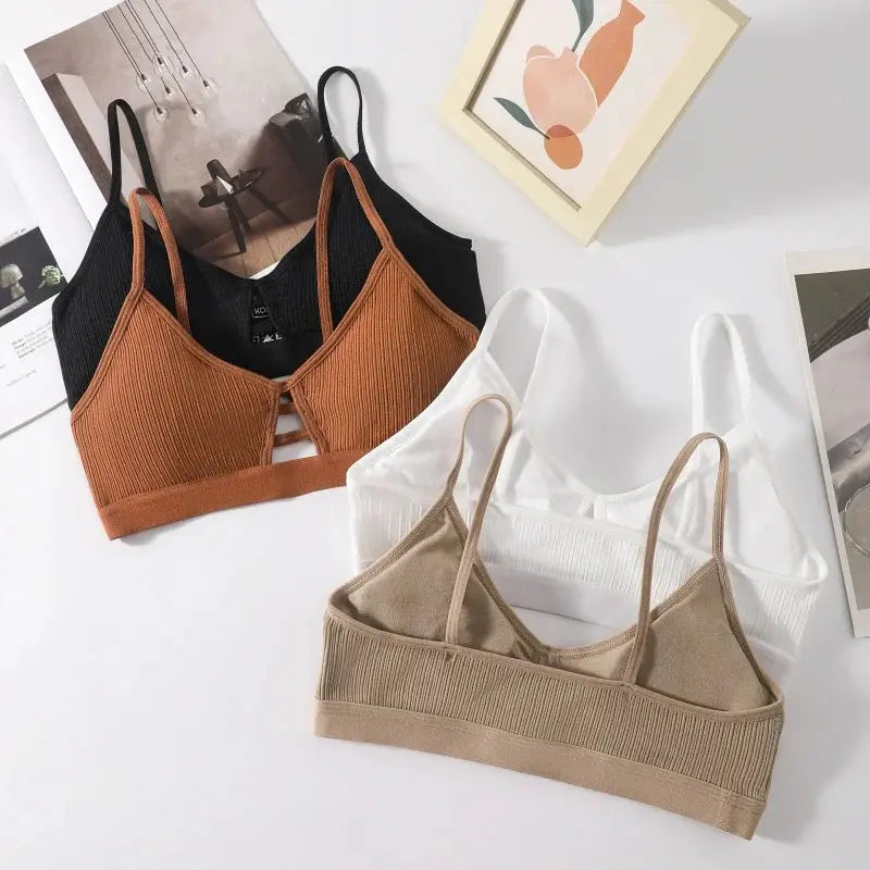 Set of four ribbed hollow-out wireless bralettes with thin straps in black, rust, white and beige.