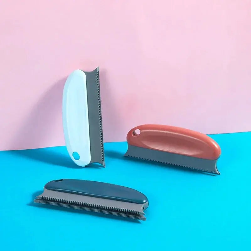 Lint hair remover brush set with three handheld fuzz removers in teal, brown, and gray on a blue surface