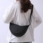 Black nylon padded crossbody bag with adjustable strap; portable women's shoulder purse.