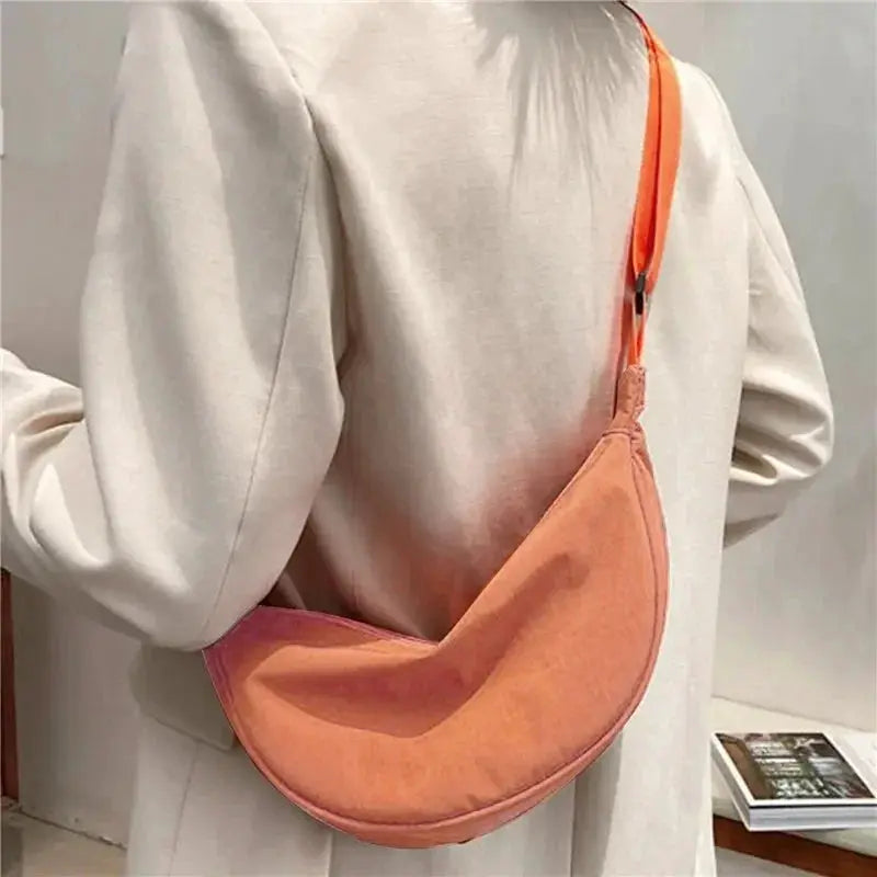Nylon dumpling bag by Simples Market, small peach-orange crescent crossbody with orange strap