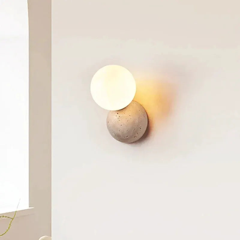 Cream-style LED wall lamp with a round white disc atop a textured stone base, Nordic bedroom light