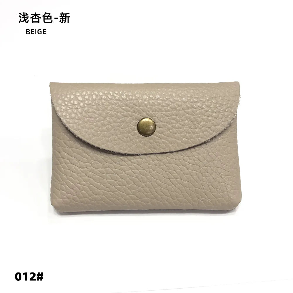 Beige genuine leather card holder with curved envelope-style flap and brass snap.