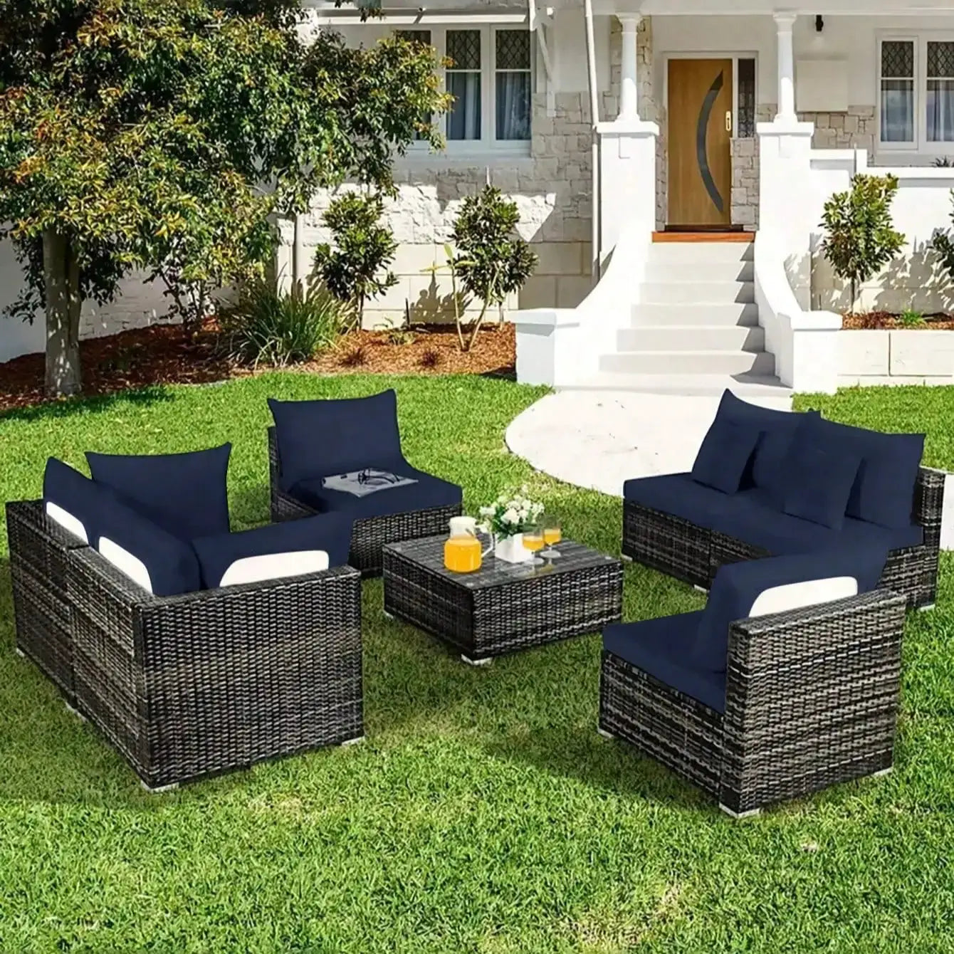 Outdoor navy sofa cushions on a wicker patio furniture set with a central coffee table