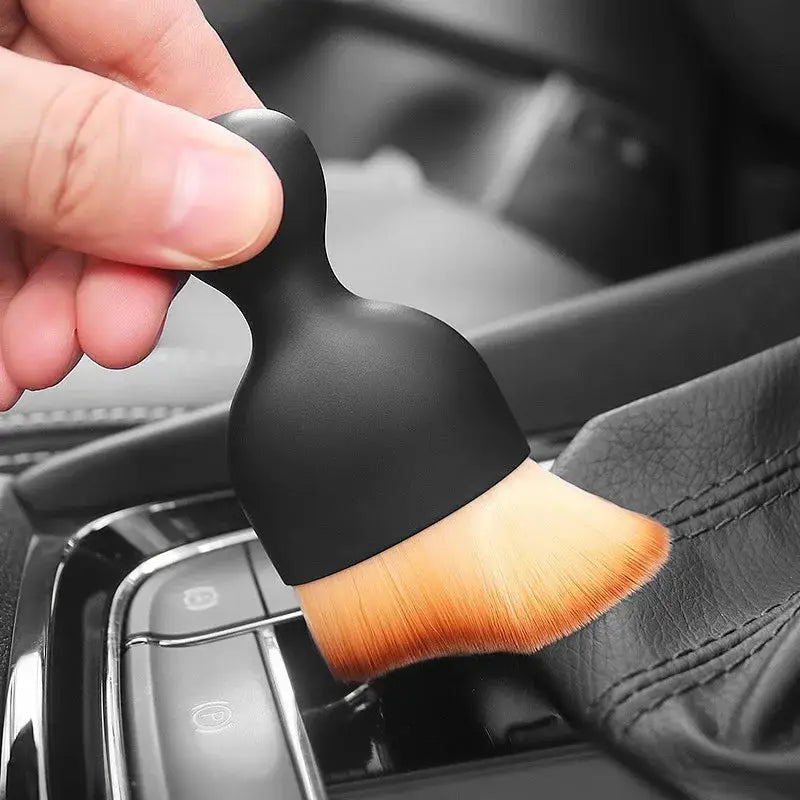 Car interior cleaning brush with orange soft bristles and black ergonomic handle