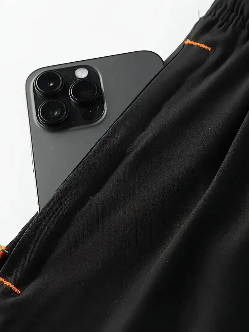 Men's black sports shorts with elastic waist, breathable fabric and orange stitching