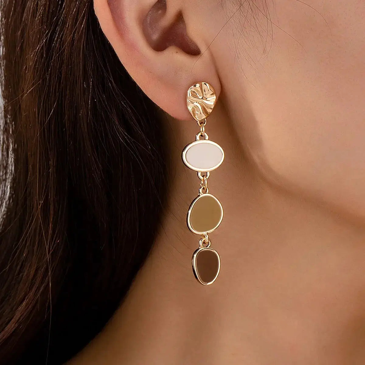 Gold-tone drop earrings with textured leaf stud and three oval resin charms in white, cream, and brown