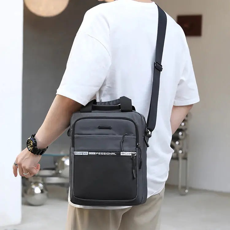 Men's crossbody bag by Simples Market in black/gray with adjustable strap and multiple front pockets.