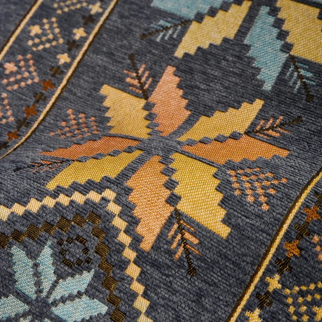 Sofa cover in Bohemian jacquard chenille with a butterfly-like motif; navy background with yellow and orange accents, Simples Market.