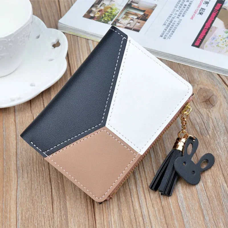 Fashion wallet with geometric color-block PU leather in black, white and beige; includes tassel charm.