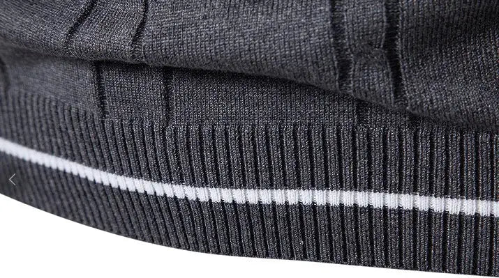 Men's knit vest close-up of charcoal gray ribbed hem with white stripe.