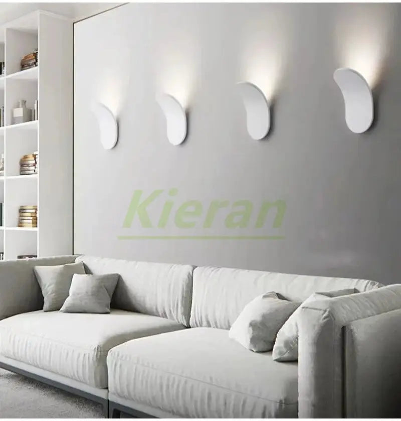Nordic skateboard LED wall lamps, 4-pack, on gray wall above white sofa, curved white fixtures