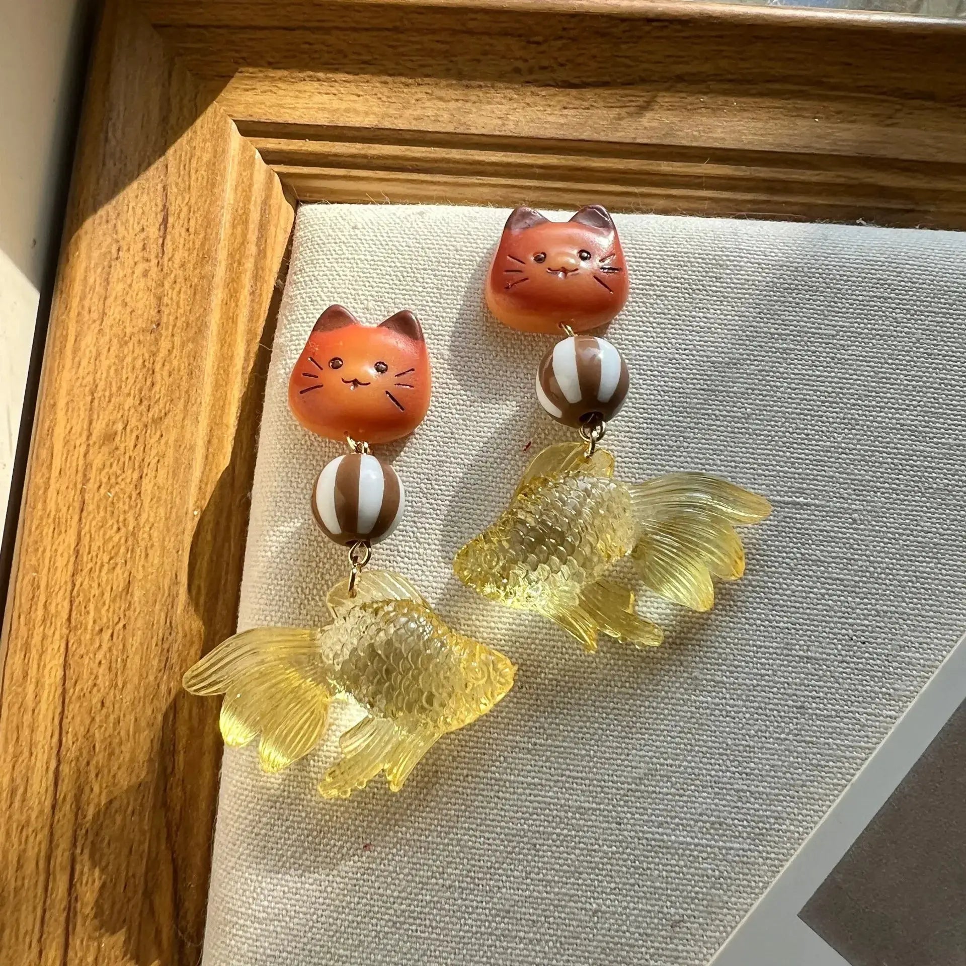 Goldfish pendant earrings pair with translucent yellow fish charms and orange cat-face beads