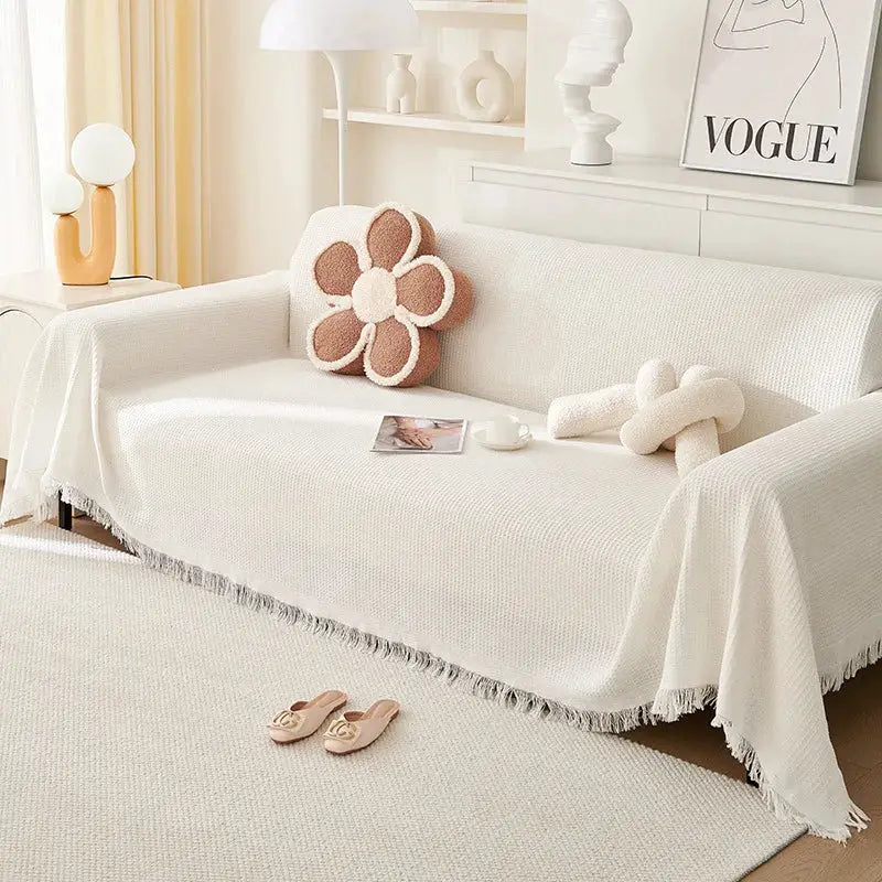 Cream wind-cotton sofa cushion cover with fringe on a white couch