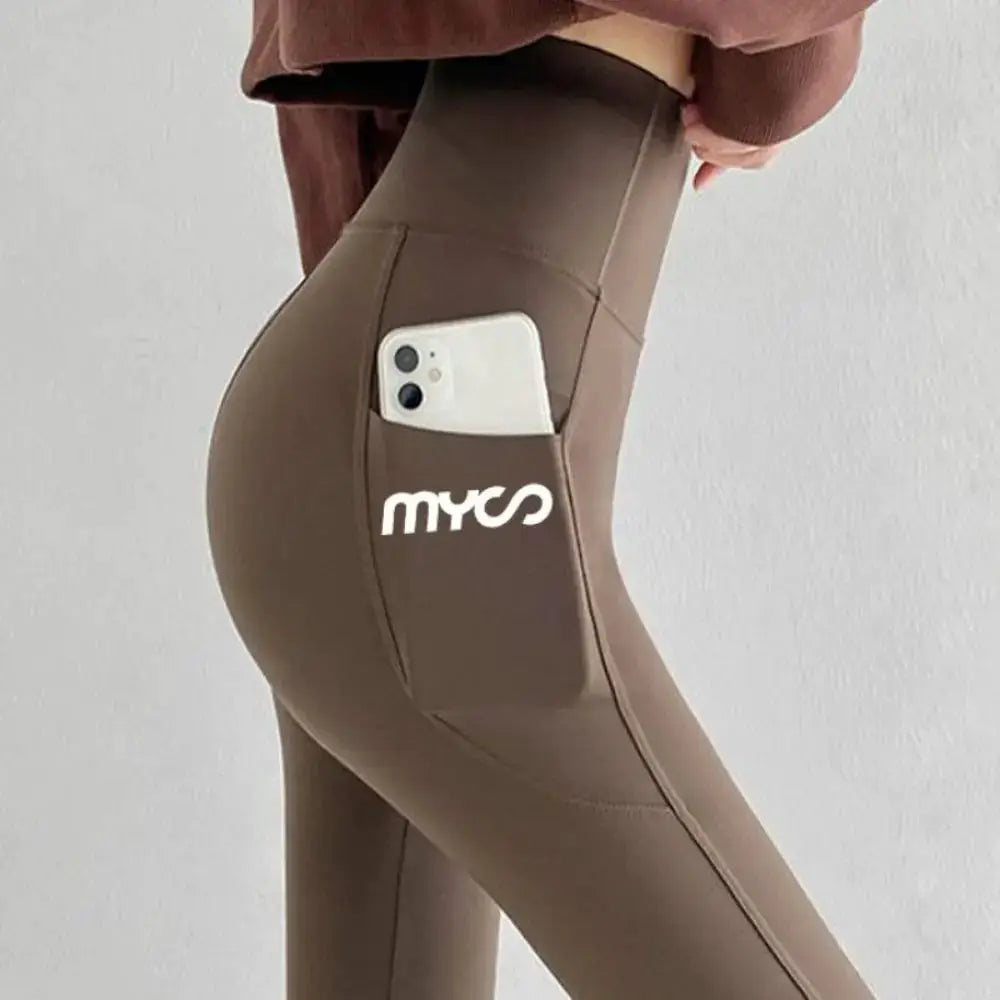 Leggings by Simples Market, solid seamless high-waist with side pocket holding a phone in taupe.