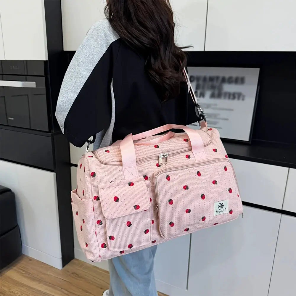 Pink strawberry-print corduroy travel bag with large capacity pockets and a shoulder strap