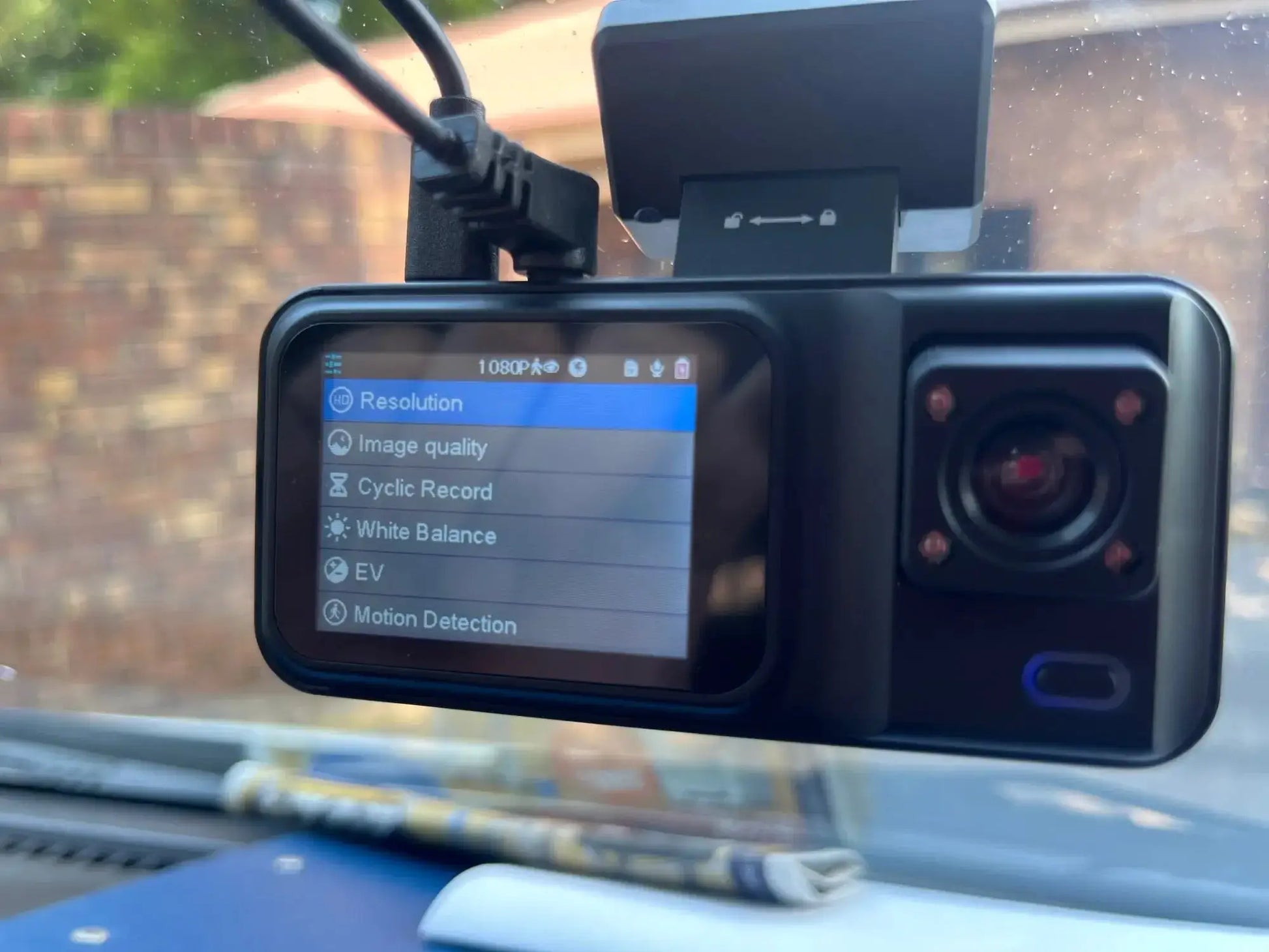 Black 3-channel car dash cam mounted on windshield with LCD screen displaying 1080P settings