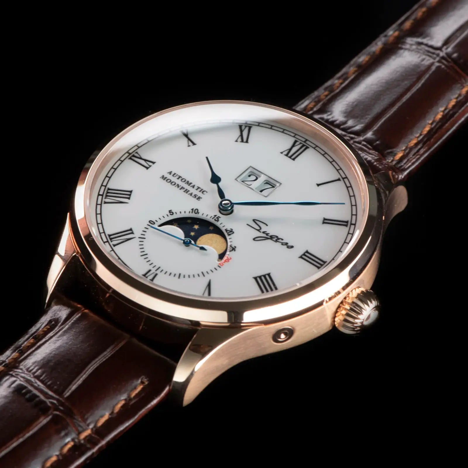 Sugess Tianjin ST25 automatic moonphase watch with white dial, rose-gold case, blue hands, and brown leather strap.