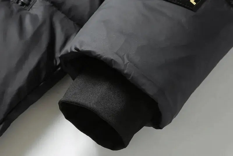 Men's black puffer jacket cuff close-up, thick down coat with ribbed knit sleeve cuff.