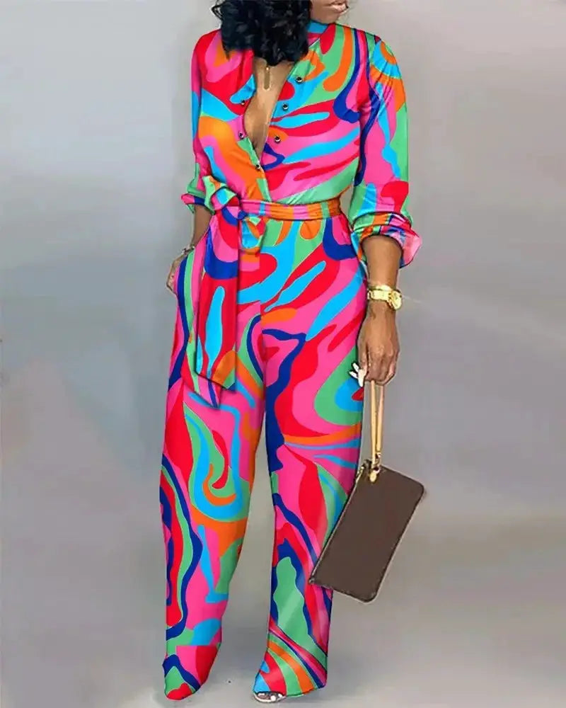 Simples Market women's jumpsuit with vibrant abstract print, long sleeves, belt at waist, wide-leg pants