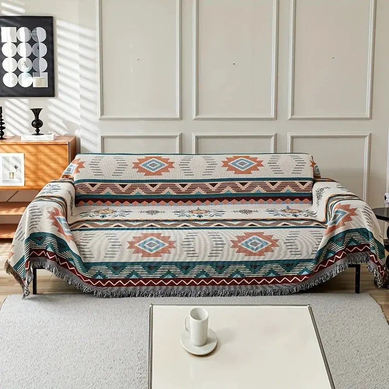 Ethnic sofa cover with geometric teal, orange, beige pattern; double-sided, fringed edges, pet-friendly.