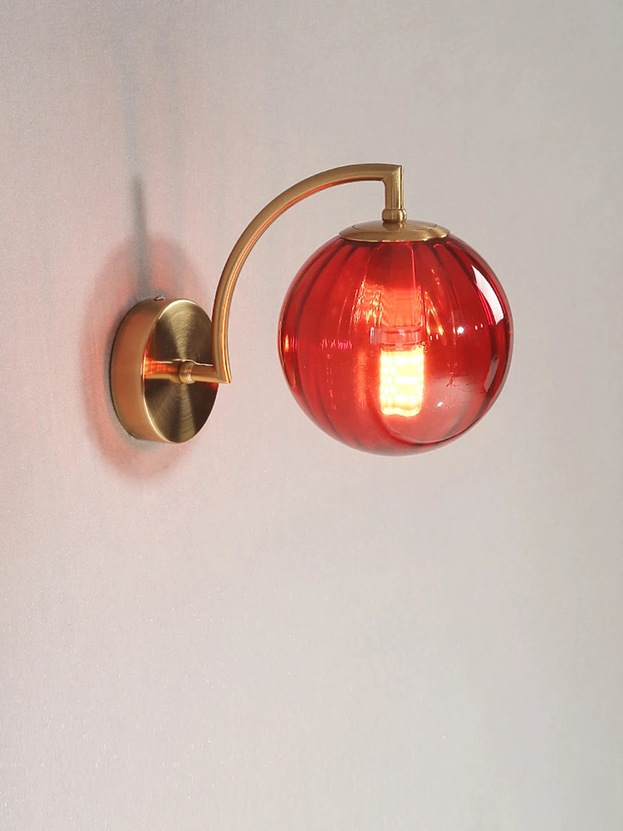 LED wall lamp by Simples Market with red glass globe shade and brass curved arm, Nordic minimalist wall sconce.