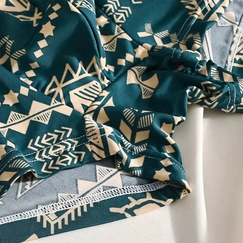 Boxer shorts fabric in teal with white geometric print and visible stitching