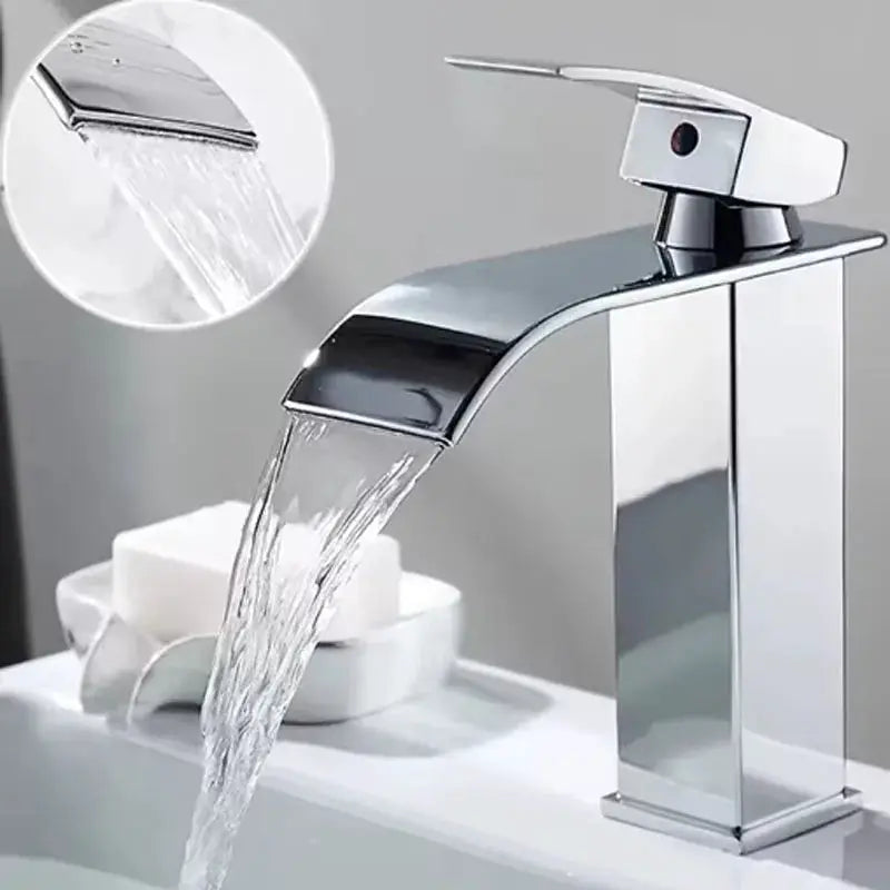 Waterfall-style chrome bathroom faucet for wash basin; tall square pillar with curved spout.