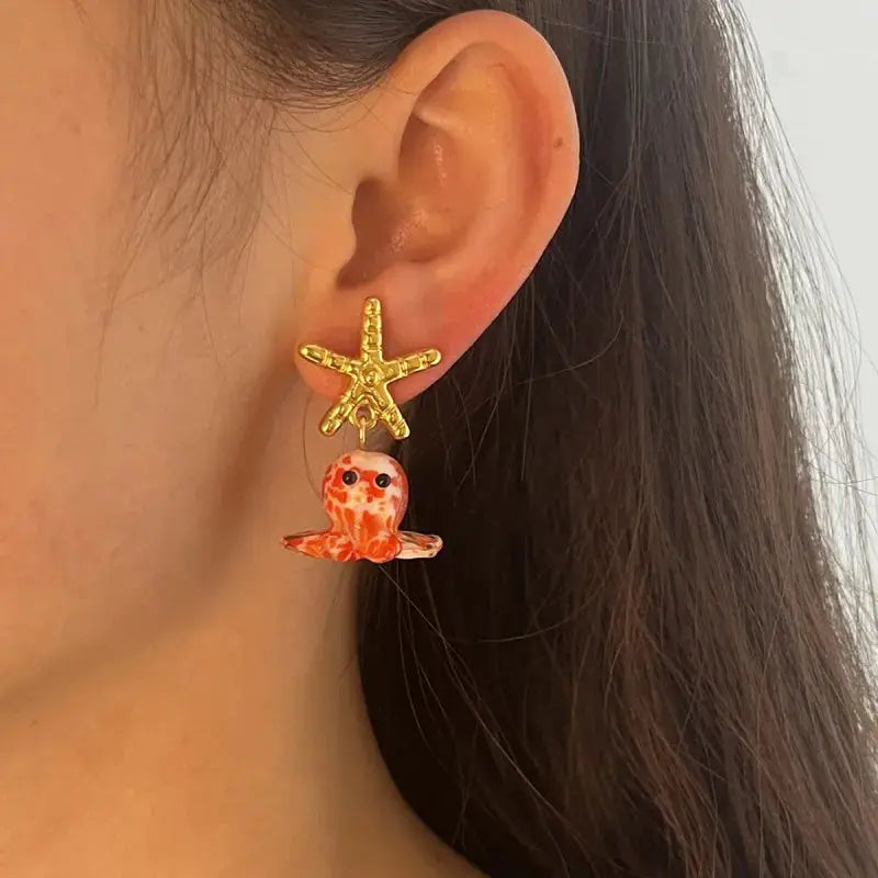 Long drop octopus earrings with gold starfish stud and orange glass octopus charm
