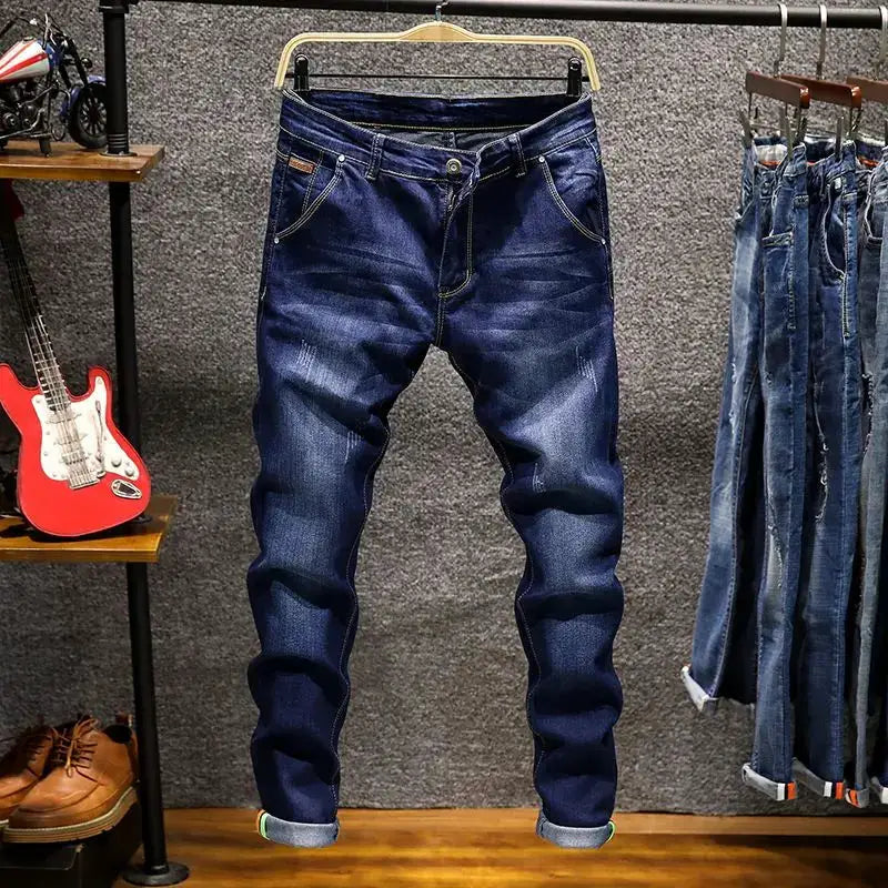 Simples Market men’s blue cotton denim elastic straight jeans with rolled cuffs on display with several other jeans