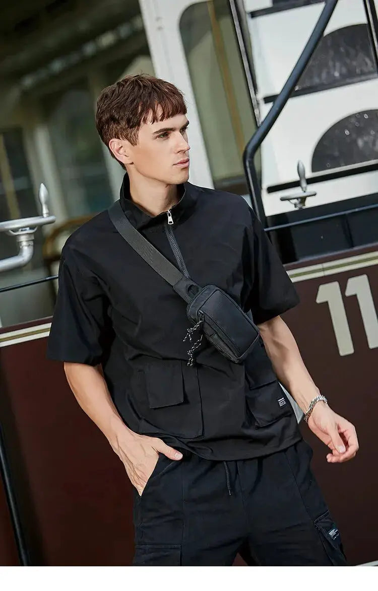 Men's crossbody bag by Simples Market; black mini chest bag worn diagonally across the chest.