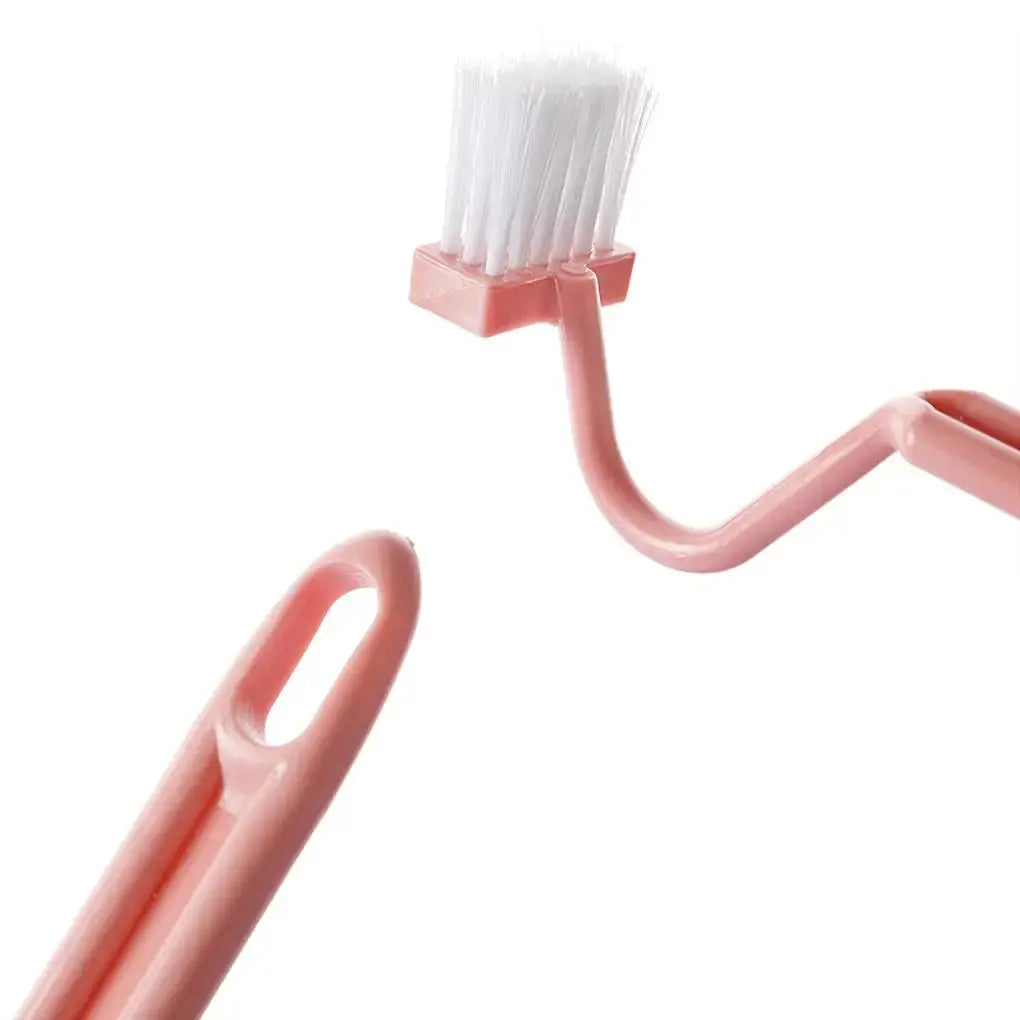 S-shaped pink toilet cleaning brush with curved handle and white bristles