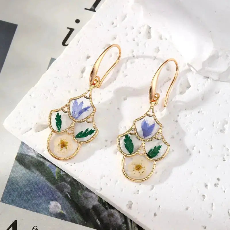 Pair of gold-tone pressed-flower dangle earrings with layered epoxy resin floral frames
