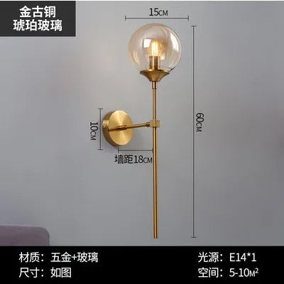 Modern glass ball wall lamp sconce by Simples Market in brass gold finish with a clear globe shade, 60 cm tall