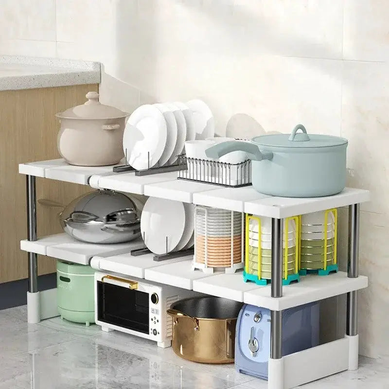 Stackable white kitchen storage rack with chrome posts, layered shelves for dishes, pots, and pans.