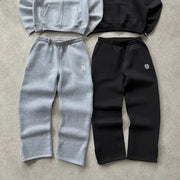 Two pairs of sweatpants by Simples Market; gray and black high-waist joggers with small logo