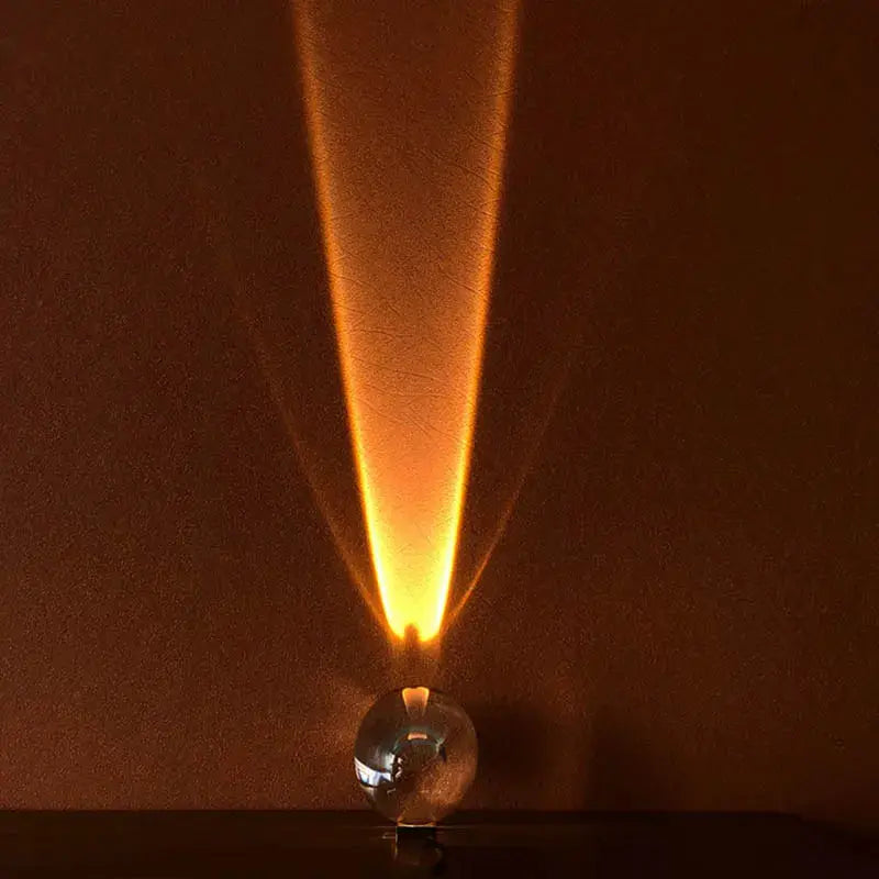 Italian designer table lamp with a glass egg-shaped base and warm amber LED projection