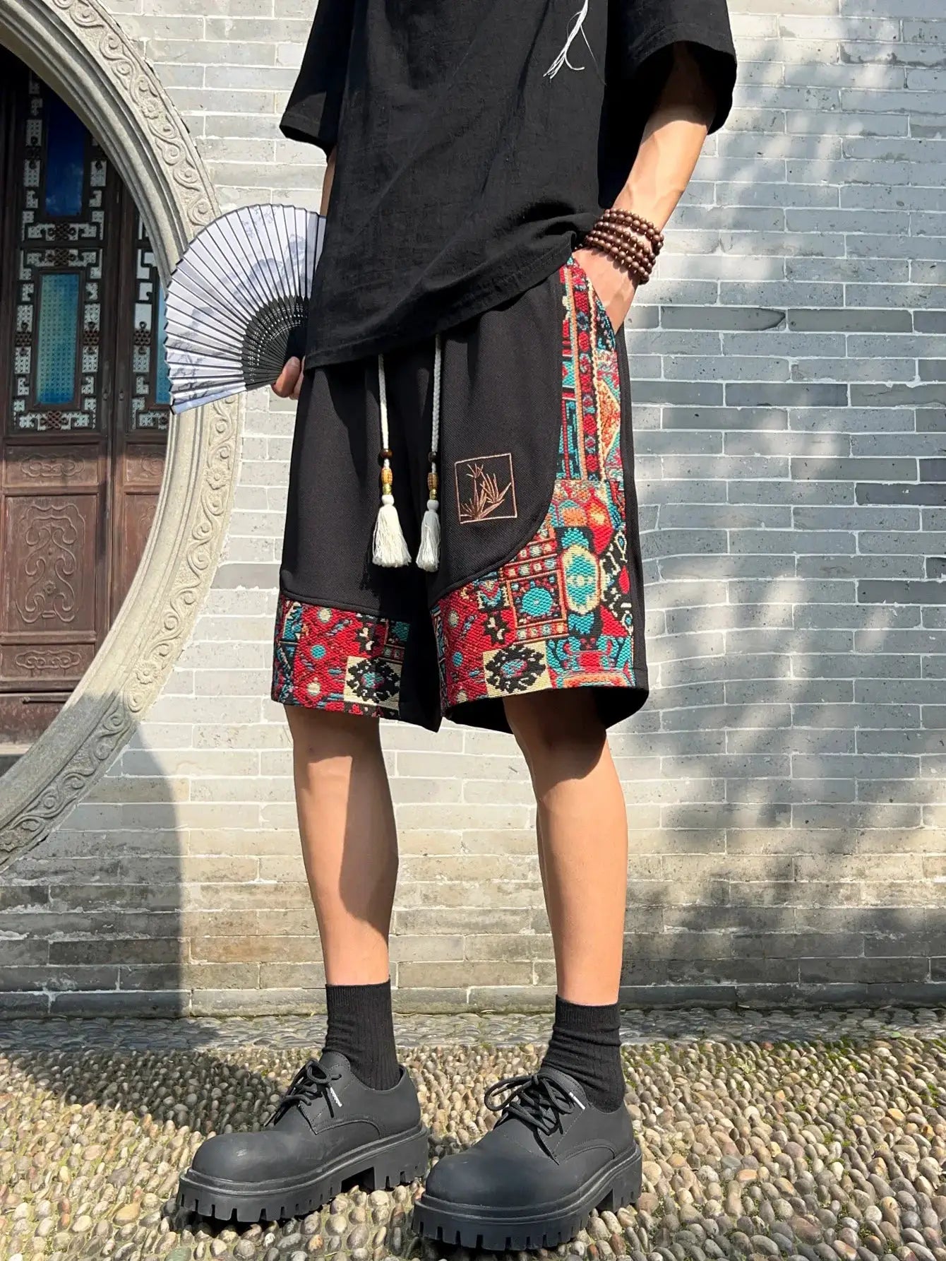 Men's ethnic embroidery shorts with pockets, black with colorful patchwork side panels and drawstring waist