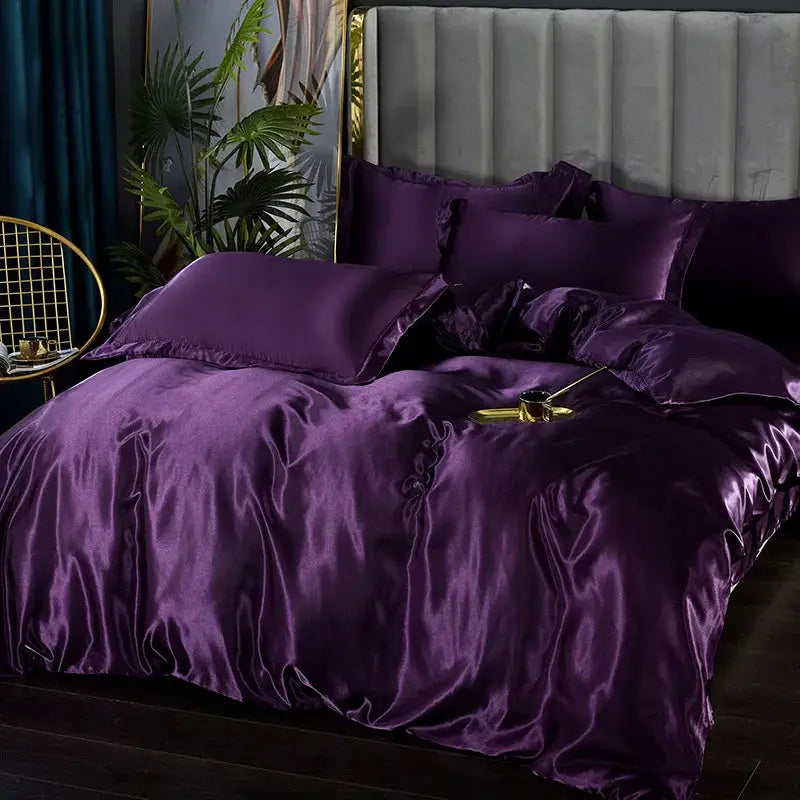 Simples Market purple silk satin bedding set with duvet cover, sheets and pillowcases on a gray upholstered bed.