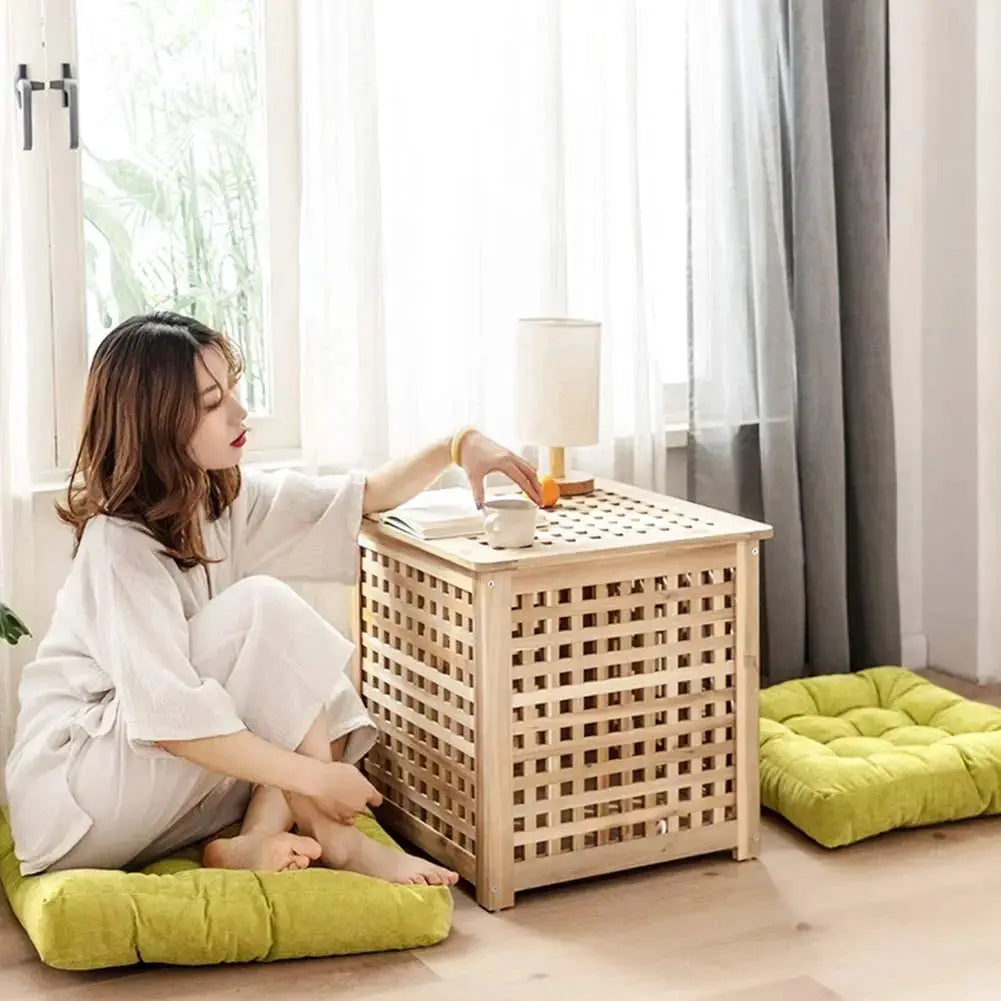 Two lime green tufted floor pillows for floor seating, shown beside a light wood lattice side table with a mug and book