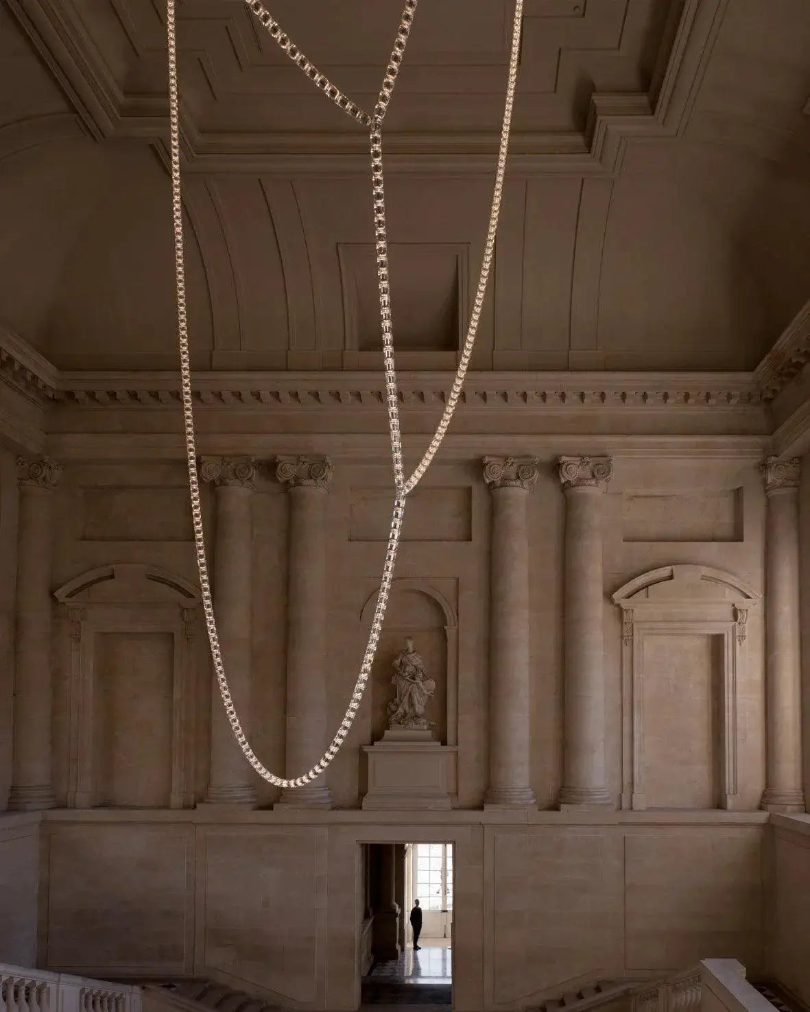 Chandelier necklace with crystal acrylic beads, multi‑strand adjustable chain, suspended in a grand hall