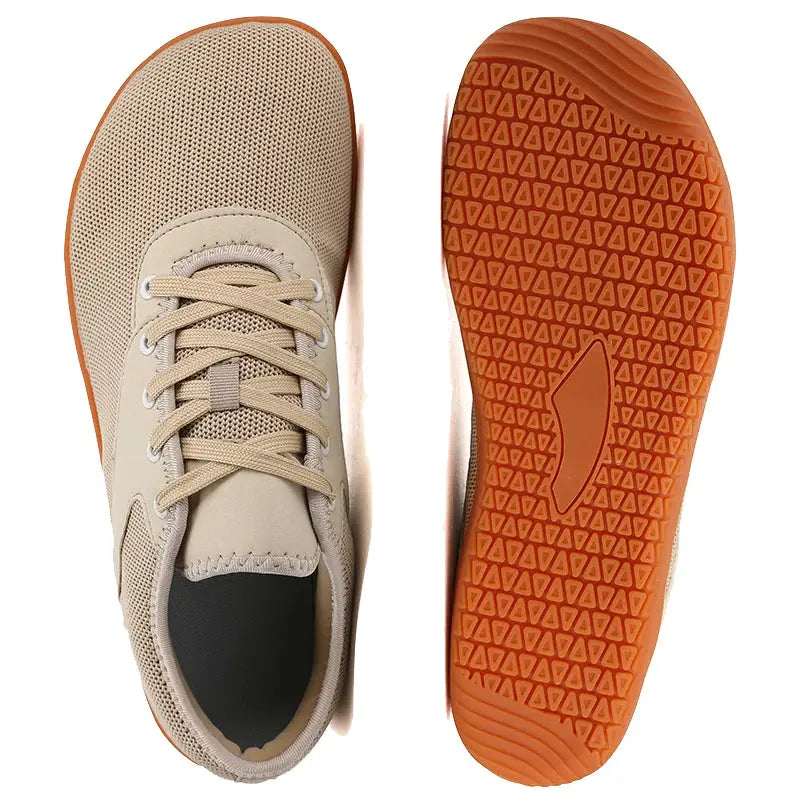 Trail running shoes pair, beige mesh upper with orange soles