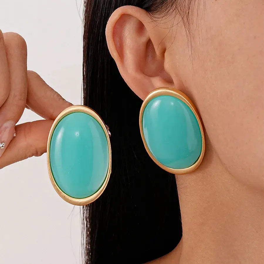 Pair of large turquoise oval resin earrings with gold-tone bezels
