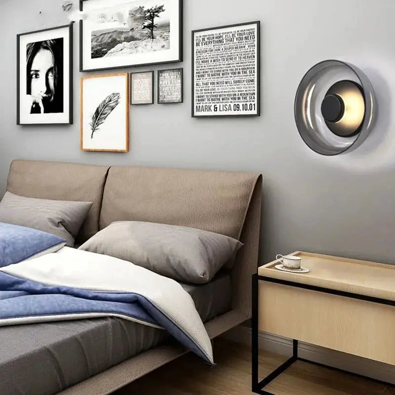Nordic LED glass wall sconce by Simples Market; circular metallic gray fixture with warm glow beside bed.